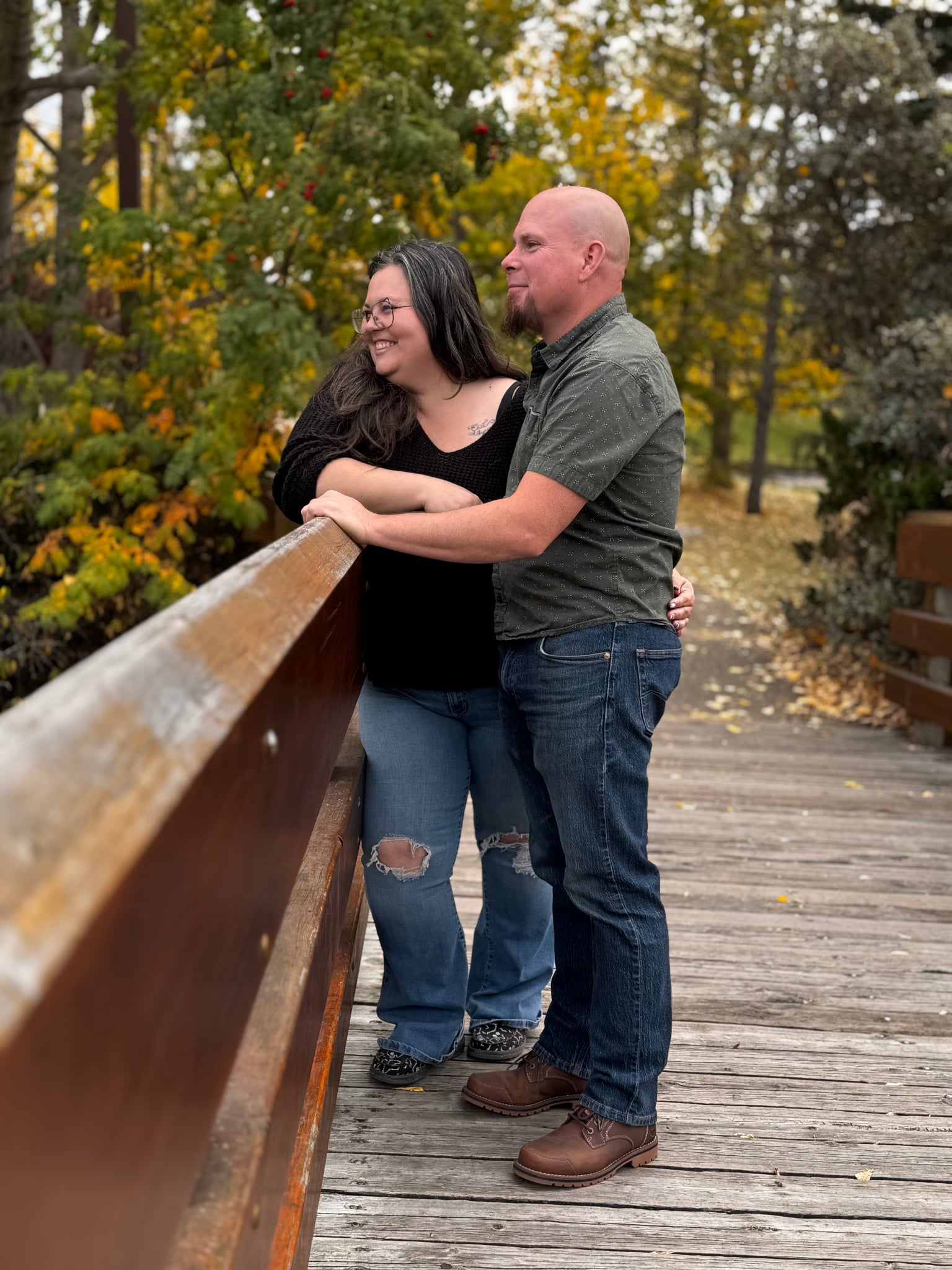 Kait outdoors on a quiet bridge surrounded by trees
